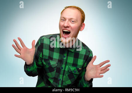 Ritratto di dai capelli rossi uomo felice mostrano le sue mani. caucasian adolescente fatta sorpresa. redhead guy urlare e risate. reazione a sorpresa è contentissimo shock. emozione è lieto. fiduciosi, ragazzo divertente sorriso Foto Stock