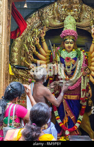 Tempio Indù Sri Vadapathira Kaliamman durante le celebrazioni Navarathiri, Singapore. Il sacerdote Indù che esegue il rituale prima della divinità Indù.e. Foto Stock
