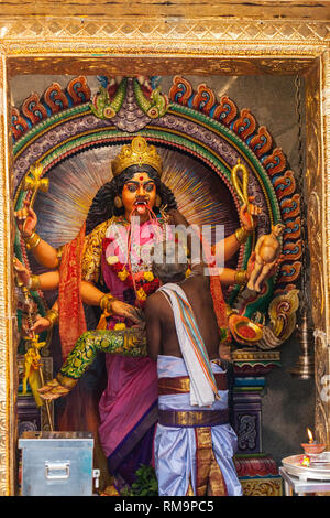 Il sacerdote Indù che attacca Garland a Periyachi Amman, Tamil Hindu Deity, Guardiano dei Bambini, al Tempio Indù Sri Vadapathira Kaliamman, Singapore. Foto Stock