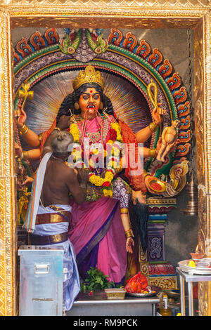 Il sacerdote Indù che attacca Garland a Periyachi Amman, Tamil Hindu Deity, Guardiano dei Bambini, al Tempio Indù Sri Vadapathira Kaliamman, Singapore. Foto Stock