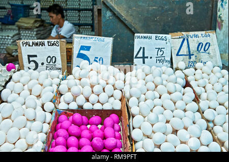 Giovane venditore a vendere il bianco e il rosso delle uova nel mercato centrale di Puerto Princesa City, Palawan Provincia, Filippine Foto Stock