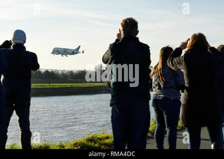 Broughton, Flintshire, Regno Unito. 14 febbraio 2019. La folla guarda il nuovo Airbus A330-743l piano di trasporto noto come Airbus Beluga terra XL a Hawarden Airport. L'aeroporto è adiacente alla fabbrica di Airbus nella periferia di Chester e questa è la prima visita del piano alla fabbrica dove rimarrà fino a sabato. Il Beluga XL è progettato per il trasporto di ali di aerei e ha il 30% in più di capacità di carico rispetto alla corrente il Beluga. Credito: Andrew Paterson/Alamy Live News Foto Stock