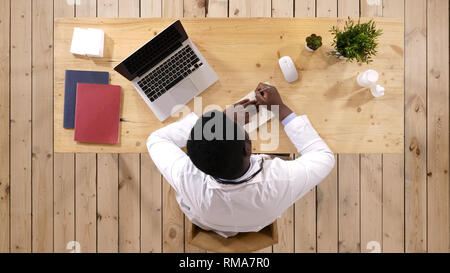 African American medico rendendo note. Foto Stock