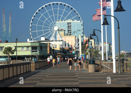 Myrtle Beach, South Carolina, Stati Uniti. La passerella con la ruota panoramica vista sullo sfondo. Foto Stock