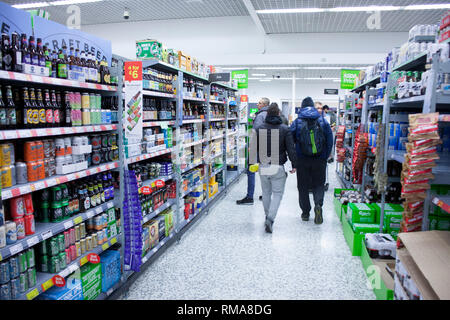 BIRMINGHAM, Regno Unito - marzo 2018 i clienti ASDA nella bevanda sezione corsia del supermercato. Bevande in bottiglia, in possibile, Tetra Pak e le caselle visualizzate su SHEL Foto Stock