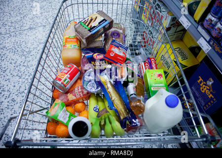 BIRMINGHAM, Regno Unito - Marzo 2018 ASDA Vista dall'alto di un assortimento di negozi di generi alimentari commestibili articoli nel carrello Trolley. Granella di marmo Pavimento decorativo del negozio. Va Foto Stock