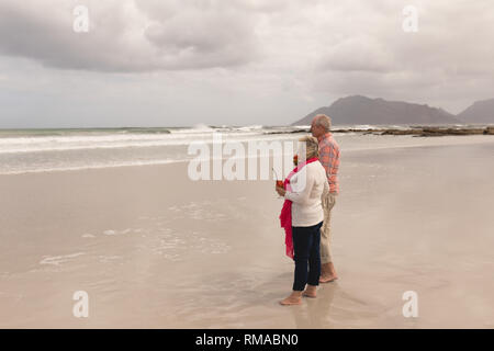 Coppia senior avente cocktail bevande sulla spiaggia Foto Stock