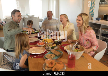 Famiglia avente pasto sul tavolo da pranzo Foto Stock