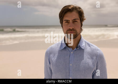 Uomo in piedi sulla spiaggia Foto Stock