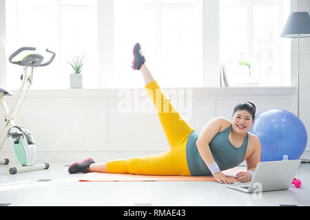 Grande ragazza di mangiare cibi sani e di esercizio per la perdita di peso, dieta concetto isolato su sfondo grigio 199 Foto Stock