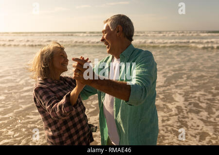 Coppia senior balli di gruppo sulla spiaggia Foto Stock