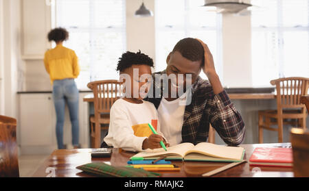 African American padre aiutando il suo figlio con i compiti a tavola Foto Stock