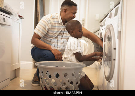 African American padre e figlio il bucato in lavatrice Foto Stock