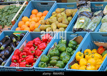 Organico fresco di frutta e verdura in cassette di plastica in stallo del mercato Foto Stock