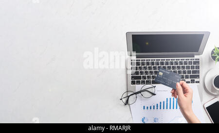 Concetto di una donna che sta facendo un acquisto online, mock up card e cellulare sulla scrivania in ufficio isolato in modo bello sfondo marmo, copia di spazio, Foto Stock