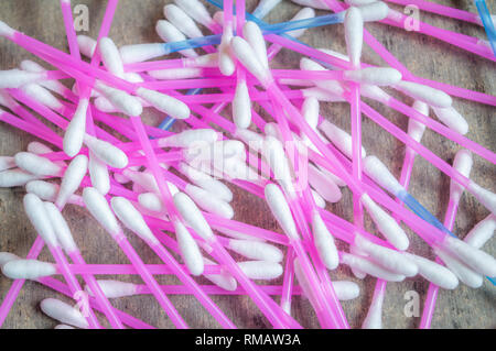 Auricolari o tamponi di cotone utilizzati per la pulizia di orecchie mantenuta su una trama Tabella grigia Foto Stock