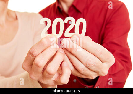 Due mani seniors visualizza l'anno 2020 come un numero Foto Stock