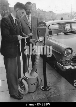 A soli 50 anni, parcometri sono già una cosa del passato. Dal 1954, sono state installate in migliaia di luoghi in Germania. Ma la tipica foto di mettere le monete o rimozione di monete da parcometro (foto, Bielefeld 1958) sono stati a lungo la nostalgia. A partire dagli anni ottanta, moderno il pagamento automatico macchine hanno ripreso i loro posti nelle aree di parcheggio. Il classico parcheggio metri stanno diventando sempre più rari nelle vie, finiscono nella spazzatura o presso i collezionisti dopo la loro 'attiva carriera". Foto Stock