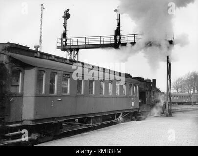 Un treno trainato da una locomotiva a vapore lascia una stazione. Foto Stock