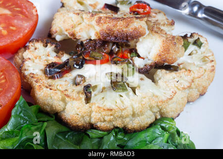 Cavolfiore arrosto di manzo servita con Spinaci appassito e pomodoro grigliate Foto Stock