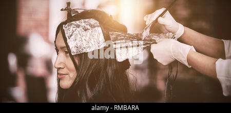 Parrucchiere la tintura dei capelli del suo cliente Foto Stock