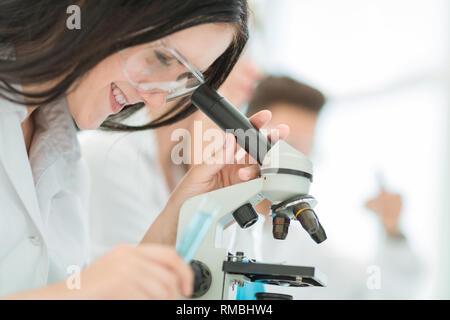 Close up.Lo scienziato guarda nel microscopio in laboratorio Foto Stock