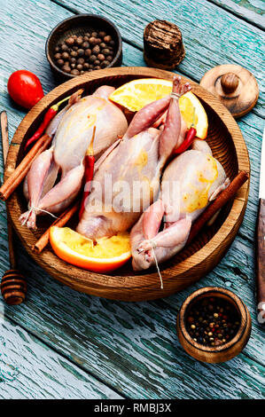 Crudo fresco quaglie e gli ingredienti nel vassoio sul tavolo della cucina Foto Stock