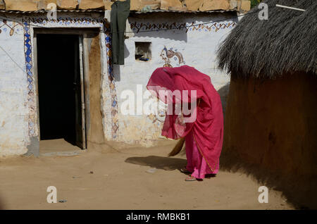 Donna spazzare il pavimento Khuri villaggio, Jaisalmer, Rajasthan, India, Asia Foto Stock