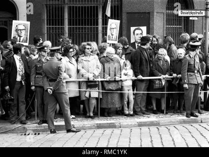 Persone con ritratti di Erich Honecker e Leonid Brezhnev attendere sul Ossietzky Strasse in Berlin-Pankow per l arrivo del per il giro della Papamobile del Soviet di leader di partito e la RDT leadership con Erich Honecker e Willi Stoph sul loro viaggio per la pensione Schloss Niederschoenhausen. Foto Stock