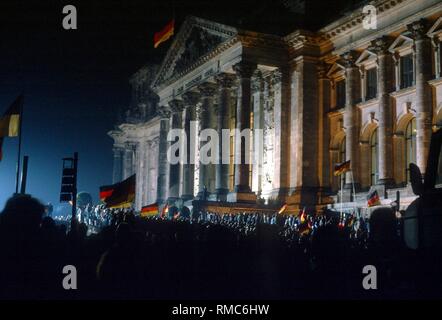 (03.10.1990) di Berlino, di fronte al Reichstag di Berlino edificio, decine di migliaia di persone festeggiano la riunificazione della Repubblica federale di Germania e la Repubblica democratica tedesca. Foto Stock