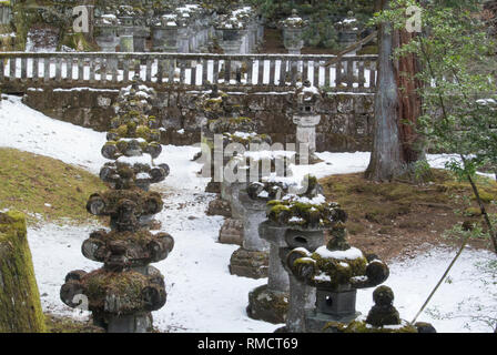 Lanterne di pietra nella neve a Tosho-gu, Nikko, Giappone Foto Stock