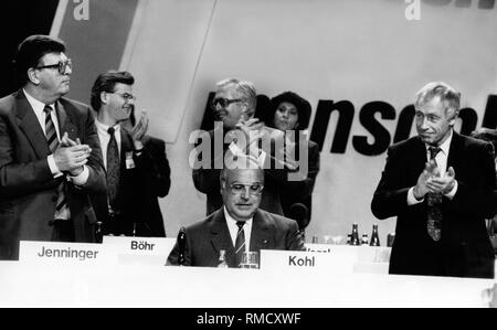 I delegati e il presidio ha applaudito il Cancelliere federale Helmut Kohl per circa tre minuti dopo il suo discorso all'inizio dell'Ufficio federale di congresso di partito della CDU in Mainz. Da sinistra: Presidente del Bundestag Philipp Jenninger, cancelliere federale Helmut Kohl, Segretario Generale Heiner Geisser. Dietro Jenninger il Presidente federale dell'Unione Junge Christoph Boehr e il Primo ministro del Land Renania-Palatinato Bernhard Vogel. Foto Stock