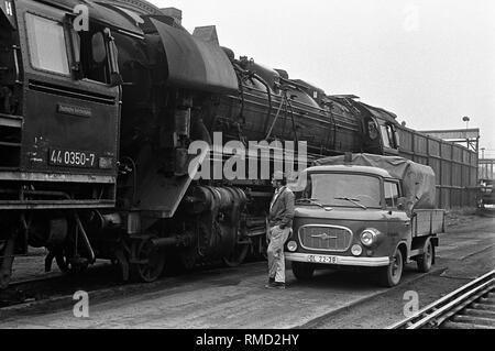 Un lavoratore si trova di fronte a una 'Barkas' pick-up nella parte anteriore di una locomotiva in materie (Reichsbahn-Ausbesserungswerk) (Reichsbahn repair shop). Foto Stock