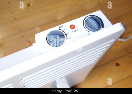 Lavoro elettrico bianco termoconvettore con il pannello di controllo sulla parte superiore su pavimento di legno in una stanza della casa vista superiore closeup Foto Stock