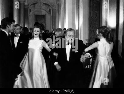 Il Primo Ministro bavarese Alfons Goppel (medio) danze con ragazze di Sanfrediano Magno e Kathleen Humphrey presso l'esordiente palla. Foto Stock