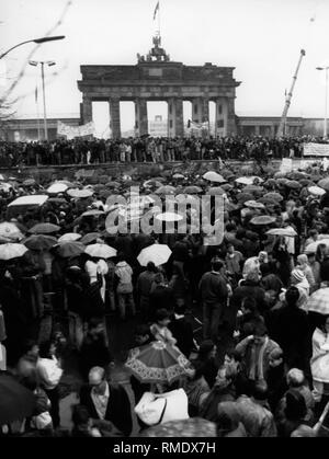 Vista la folla presumibilmente nel giorno di apertura della Porta di Brandeburgo di fronte e sul muro di Berlino. Foto Stock