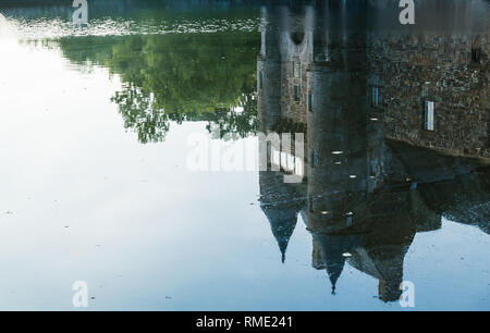 Riflesso nello stagno delle torrette del XIV secolo Chateau de Trecesson Foto Stock