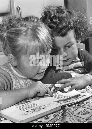 Due bambini di leggere un libro di fotografia, 50s Foto Stock