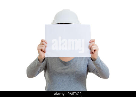Giovane donna ingegnere indossare casco protettivo, tenendo un vuoto del foglio di carta che copre il volto isolate su sfondo bianco. Foto Stock