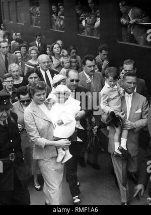 Presso la Stazione Centrale di Monaco Roberto Rosselini (con gli occhiali da sole) e Ingrid Bergman fanno la loro strada attraverso la folla, che ha riunito per salutare Bergman. Ingrid Bergman visite di Monaco di Baviera per la prima volta dal 1938. Foto Stock