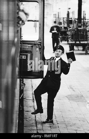 Un conduttore dà il treno il segnale di partenza alla piattaforma per la stazione principale di Wuerzburg. Foto Stock