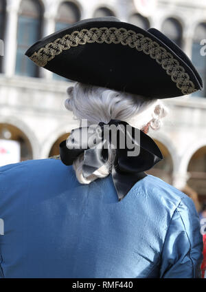 Persona mascherata con grande cappello e parrucca durante il carnevale veneziano festival Foto Stock