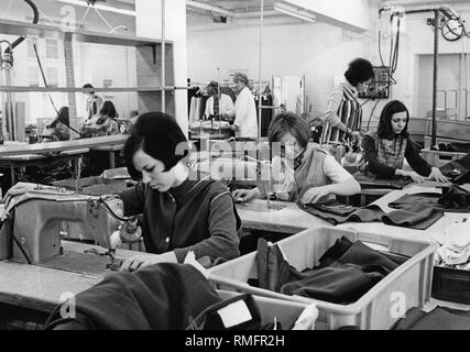 Donna che lavorano nell'industria tessile: Immagine mostra giovane donna durante il lavoro con macchine da cucire. Foto Stock