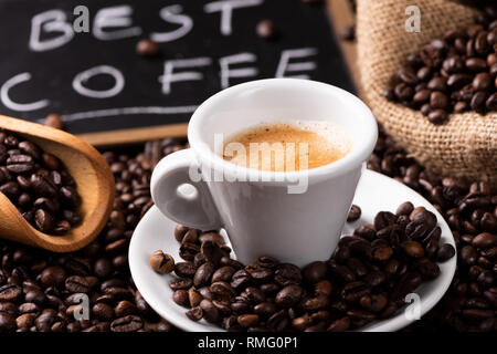 Expresso coffee cup close-up su dark caffè torrefatto in grani Foto Stock