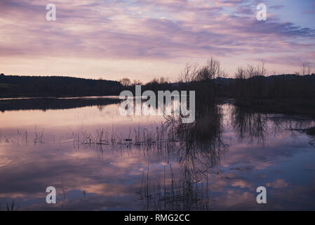La sera Nuvoloso cielo sopra il lago calmo Foto Stock