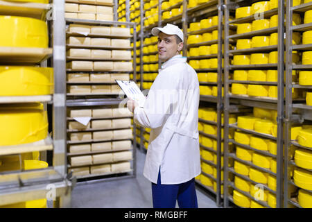 Ispettore rende note in foglio in corrispondenza del magazzino di formaggio Foto Stock