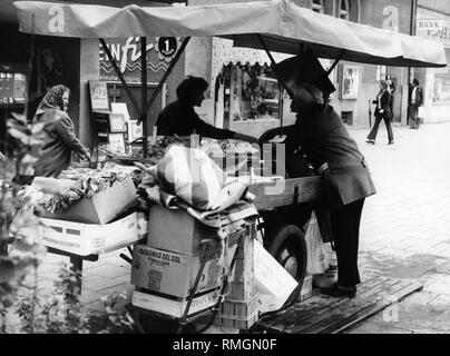 Una donna negozi da un fruttivendolo a food cart in Leopoldstrasse nel quartiere di Schwabing Monaco di Baviera. Foto Stock