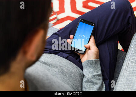 LONDON, Regno Unito - Sep 21, 2018: uomo utilizzando il nuovo Apple iPhone Xs con l immenso OLED display Retina e un12 bionic chip, guardando oltre l'app applicazioni per la connessione a Skype Foto Stock