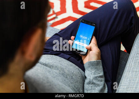 LONDON, Regno Unito - Sep 21, 2018: uomo utilizzando il nuovo Apple iPhone Xs con l immenso OLED display Retina e un12 bionic chip, guardando oltre l'app applicazione Skype communicator app Foto Stock