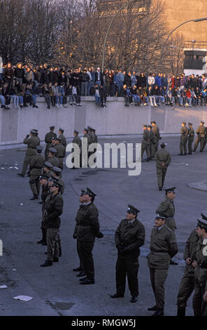 Migliaia di oriente e occidente i berlinesi celebrare l'apertura della frontiera sul muro di Berlino alla Porta di Brandeburgo. GDR guardie di frontiera di impedire alle persone di entrare nella zona soggetta a restrizioni nella piazza davanti alla Porta di Brandeburgo e il Pariser Platz. Foto Stock